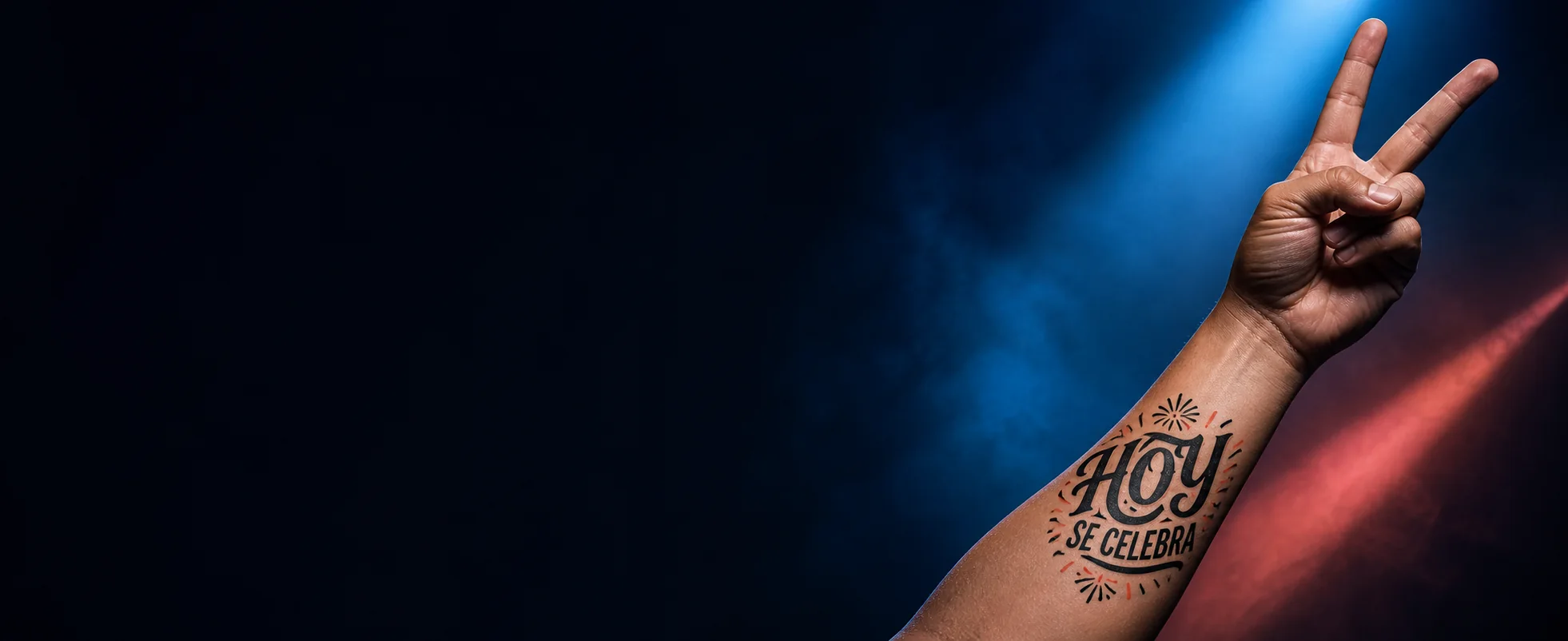 Antebrazo con el tatuaje temporal Hoy se celebra y una mano haciendo el símbolo de paz
