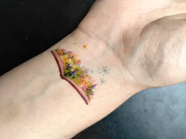 Tatuaje temporal floral inspirado en un libro, aplicado en la muñeca para FILBo