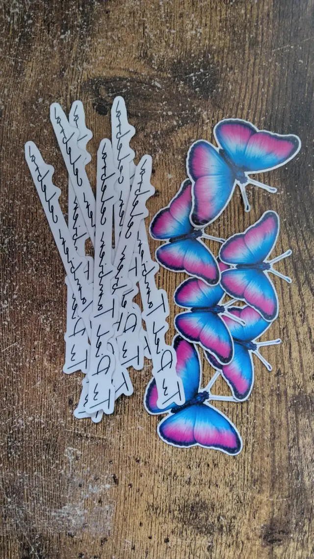 Tatuajes temporales de mariposas azules y rosas con tiras caligráficas producidos para Merck